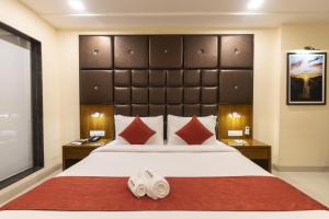 罗纳瓦拉The Metropole by Keyboard Hotels的卧室里有一张带大床的大床