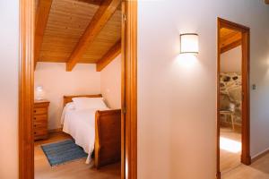 una camera da letto con un letto e uno specchio di O Lar do Bispo by CABANA Rentals a Arbo