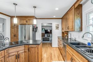 a kitchen with wooden cabinets and a stainless steel refrigerator at The Chestnut Cottage by Stay Local Nashville in Brentwood