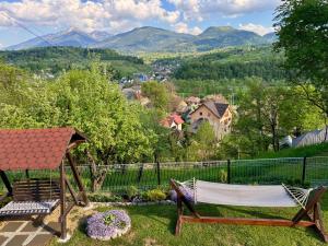a hammock in a yard with mountains in the background at Casa Ioana Moisei in Moisei