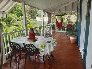 une table sur le porche d'une maison dans l'établissement Charmant bungalow à Bouillante avec vue sur la mer, à Bouillante