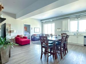 a living room with a table and a red couch at Contemporary East Loft in Historic Niagara in Niagara on the Lake