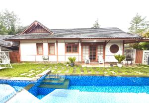 a house with a swimming pool in front of a house at SF Homey Yokohama in Cikundul