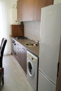 a kitchen with a refrigerator and a washing machine at Skyline Apart 1 Militari Residence in Roşu
