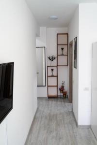 an empty hallway with white walls and a television at Skyline Apart 1 Militari Residence in Roşu
