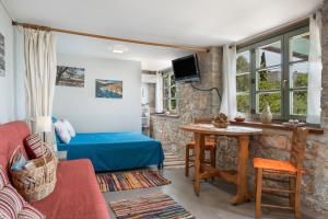 een woonkamer met een blauw bed en een tafel bij Boutique Stone Cottage House in Panormos Kalymnos