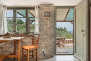 een keuken met een tafel en een stenen muur bij Boutique Stone Cottage House in Panormos Kalymnos