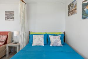 een slaapkamer met een blauw bed en een bank bij Boutique Stone Cottage House in Panormos Kalymnos