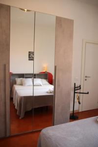 a bedroom with a bed and a mirror at Cosy apratment near PortaVescovo train station in Verona