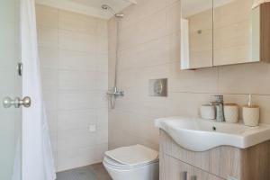 een witte badkamer met een wastafel en een toilet bij Boutique Stone Cottage House in Panormos Kalymnos +34 foto's