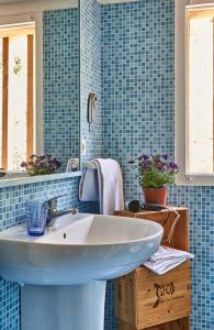 a bathroom with a white sink and blue tiles at Elegant Seaview Home w AC e Free Private Park in Simius