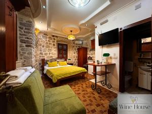 a bedroom with a bed and a couch and a table at Apartments Wine House Old Town in Kotor