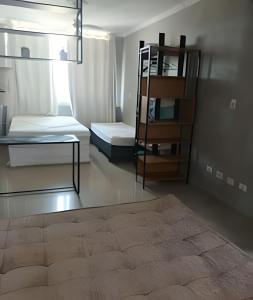 a room with two beds and a shelf at Studio à Beira-mar - Santos in Santos