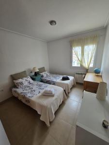 a bedroom with two beds and a desk and a window at Mar Menor Golf Resort , La maison bleue, villa piscine privée in Los Martínez +10 photos