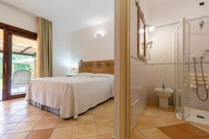 a bedroom with a bed and a shower and a toilet at Porto Giunco Residence in Villasimius +37 photos