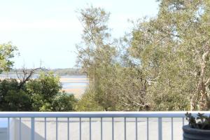 a balcony with a view of a river and trees at The Beach Deck Cotton Tree On The Esplanade in Maroochydore
