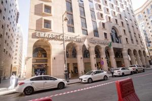 three cars parked in front of a building at Emaar Taiba Hotel in Al Madinah