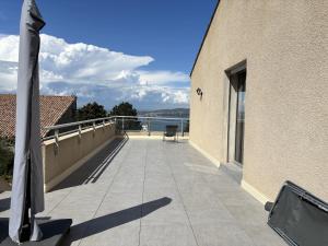 a balcony of a building with a view of the water at Sète, grande villa familiale avec Jacuzzi in Sète