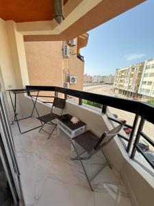 a balcony with two chairs and a table on a building at Regency Towers Apartments in Hurghada