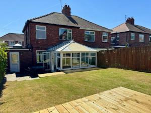 a house with a conservatory in a yard at Whitley Family Retreat, Fabulous extended home in Whitley Bay