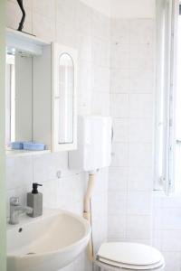 a white bathroom with a sink and a toilet at Cosy apratment near PortaVescovo train station in Verona