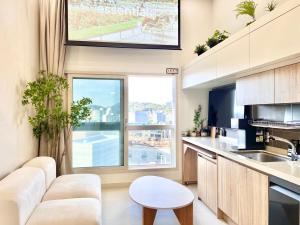 een keuken met witte meubels en een groot raam bij Hongdae Luxury Stay in Seoul