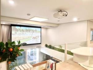 een groot projectiescherm in een woonkamer bij Hongdae Luxury Stay in Seoul +57 foto's