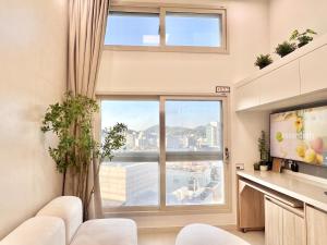 een woonkamer met een groot raam en witte stoelen bij Hongdae Luxury Stay in Seoul
