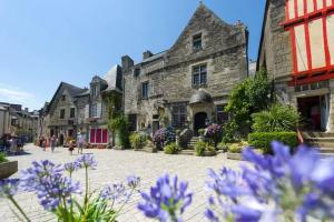 un edificio in pietra con fiori viola di fronte di Lodge de Penfrat, une parenthèse en campagne aux portes de la ville a Quimper