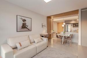 sala de estar con sofá blanco y comedor en 304 Axis Home Loft Alto Padrão, en Porto Alegre