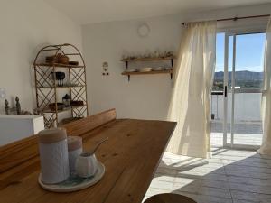 a living room with a wooden table and a window at Casa Agua Marfil in Capilla del Monte