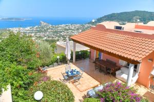 a house with a patio with a table and chairs at Villa Bianca Un angolo di paradiso in Ischia