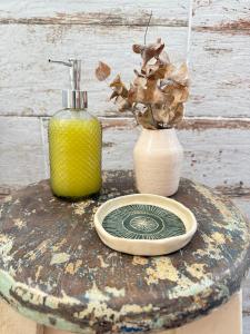 een tafel met een fles, een bord en een vaas bij Casa Agua Marfil in Capilla del Monte