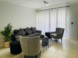 a living room with a couch and two chairs at Lifestyle apartment in Sandton - Urban61 in Sandton
