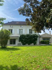 a large white house with a grass yard at Les Suites de Marie-Lot in Vire-sur-Lot