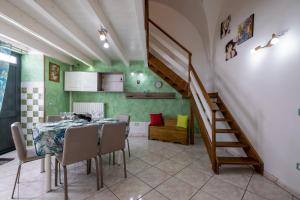 a dining room with a table and a staircase at Appartamento Green in Giurdignano +14 photos