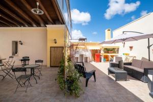 a patio with chairs and tables and umbrellas at Appartamento Green in Giurdignano