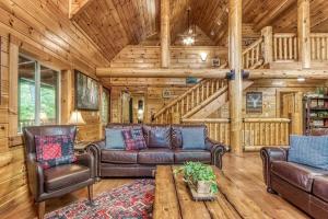 a living room with leather furniture in a log cabin at The Lodge at Glades by Avada Properties in Gatlinburg