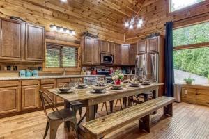 a large kitchen with a wooden table and a bench at The Lodge at Glades by Avada Properties in Gatlinburg