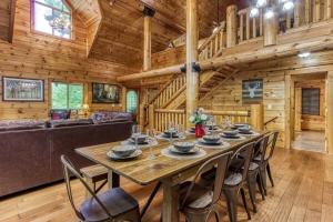 a dining room with a large wooden table and chairs at The Lodge at Glades by Avada Properties in Gatlinburg