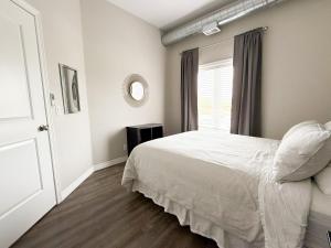 ナイアガラ・オン・ザ・レイクにあるContemporary West Loft in Historic Niagaraの白いベッドと窓のある寝室