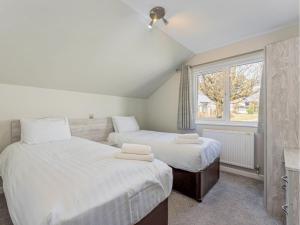 ein Schlafzimmer mit zwei Betten und einem Fenster in der Unterkunft Golden Coast Leisure Park - Ocean Tide Villa I in Woolacombe