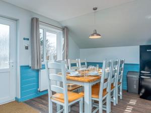 ein Esszimmer mit einem Tisch und einigen Stühlen in der Unterkunft Golden Coast Leisure Park - Ocean Tide Villa I in Woolacombe + 3 Fotos