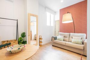 Una sala de estar con un sofá y un espejo. en Apartamentos Luna Suites Palacio Dorita, en Granada 114 fotos más