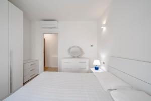 una camera bianca con letto e lampada di Parco Comfort Suite Battaglia Appartamenti a Milano