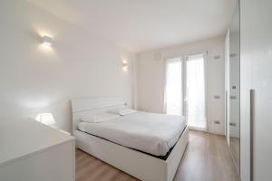 una camera da letto bianca con un letto e una finestra di Parco Comfort Suite Battaglia Appartamenti a Milano Altre 29 foto