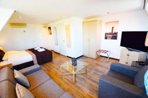 une chambre d'hôtel avec un canapé et un lit dans l'établissement Hotel Noordzee, à Domburg