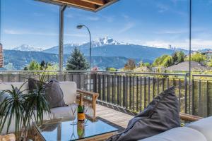 a patio with a table and chairs on a deck with mountains at Apartment Zittera - Adults only in Innsbruck