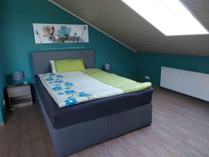 a bed in a bedroom with a blue wall at Cebullas Ferienwohnung in Herzberg am Harz