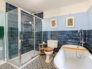 a blue tiled bathroom with a toilet and a tub at Overchurch in Hythe +33 photos